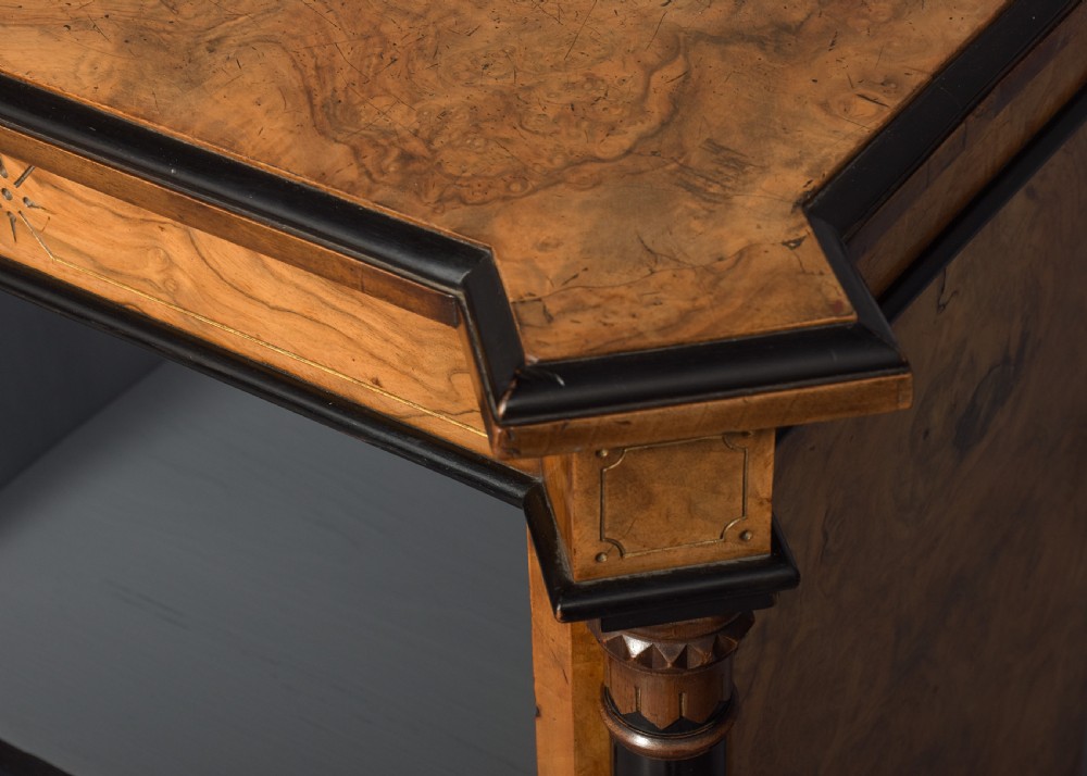 A low three-section open bookcase made of figured burr walnut featuring ebonised turned columns and a grey painted interior. View V