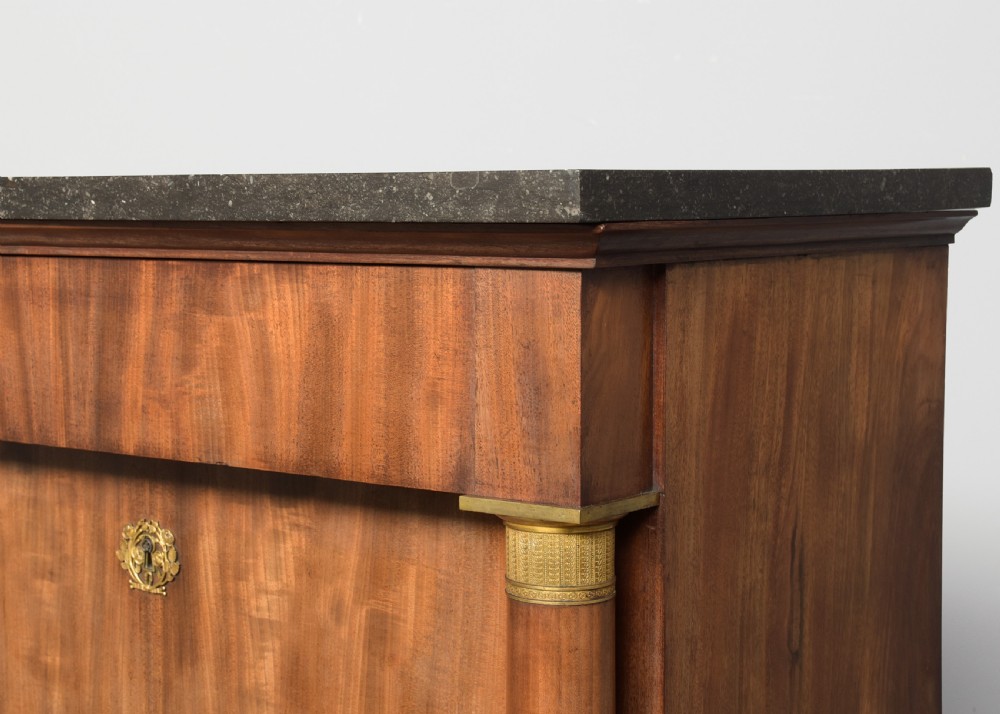 A tall mahogany secretaire abattant featuring a dark marble top, a drop-front writing panel flanked by turned columns, and three lower drawers with brass handles. View III