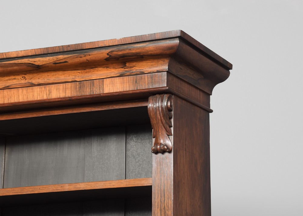 A tall William IV rosewood open bookcase featuring two upper shelf sections over lower bays with carved corbels and a solid plinth base. View III