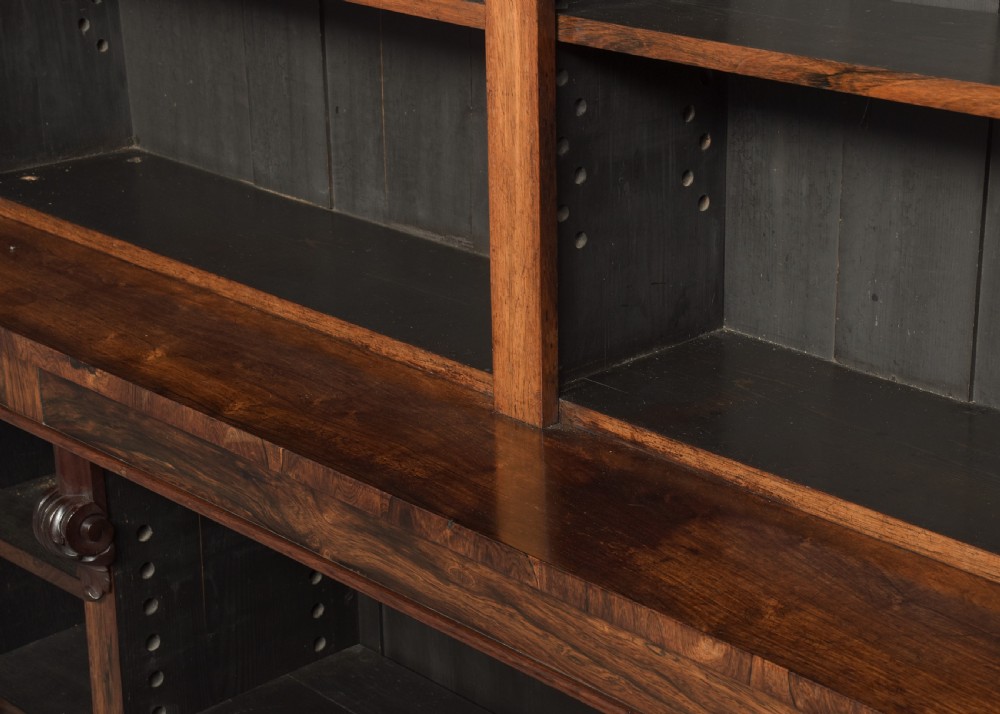 A tall William IV rosewood open bookcase featuring two upper shelf sections over lower bays with carved corbels and a solid plinth base. View VI