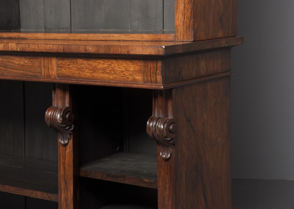 A tall William IV rosewood open bookcase featuring two upper shelf sections over lower bays with carved corbels and a solid plinth base. View VIII