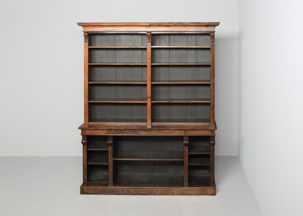 A tall William IV rosewood open bookcase featuring two upper shelf sections over lower bays with carved corbels and a solid plinth base. View IX