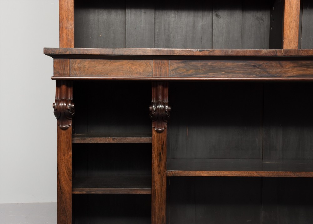 A tall William IV rosewood open bookcase featuring two upper shelf sections over lower bays with carved corbels and a solid plinth base. View X