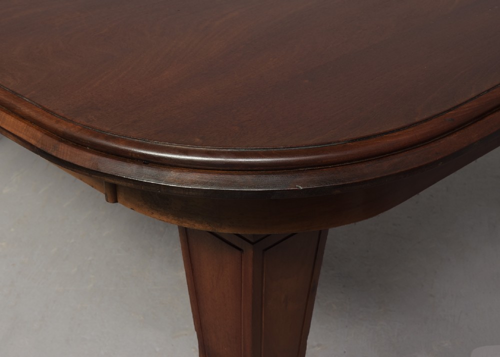 A large rectangular Victorian mahogany extending dining table featuring rounded corners, faceted tapered legs, a fifth central support leg, and brass castors. View II