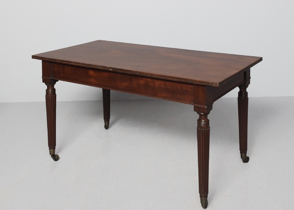 A Regency mahogany twin-pedestal extending dining table supported by reeded splayed legs with brass castors. View VI