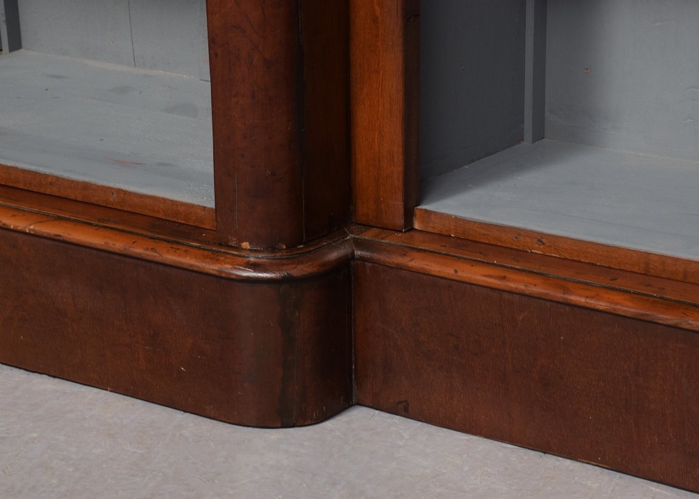 A large mid-Victorian three-section open mahogany bookcase with a breakfront centre, filled with rows of leather-bound books. View IV