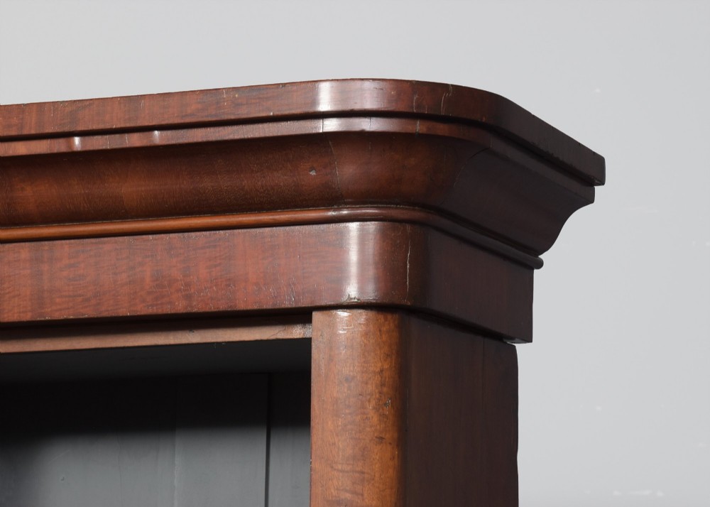 A large mid-Victorian three-section open mahogany bookcase with a breakfront centre, filled with rows of leather-bound books. View V