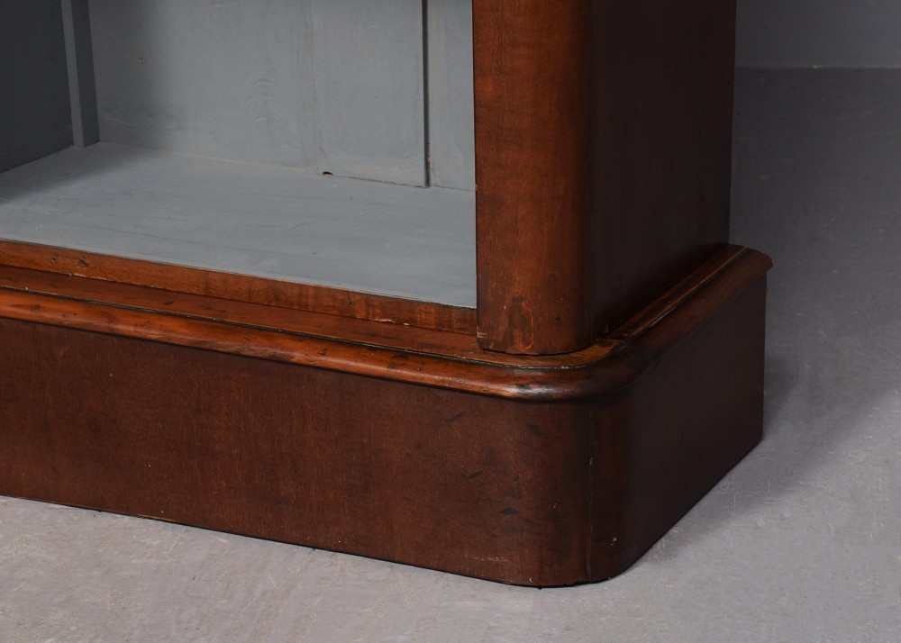 A large mid-Victorian three-section open mahogany bookcase with a breakfront centre, filled with rows of leather-bound books. View VI