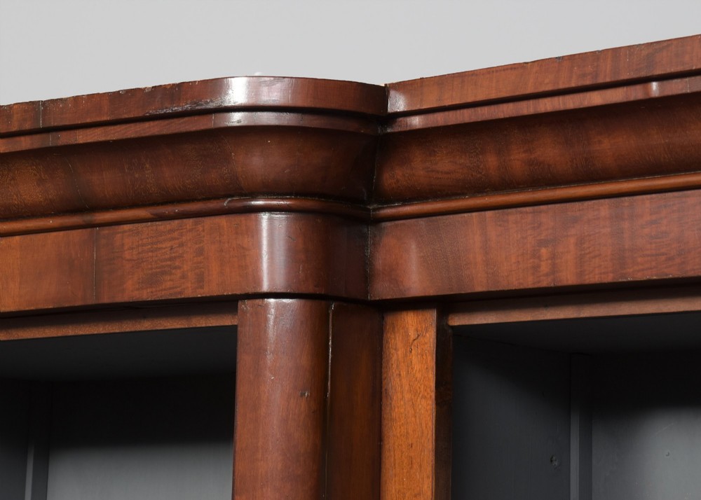 A large mid-Victorian three-section open mahogany bookcase with a breakfront centre, filled with rows of leather-bound books. View VII