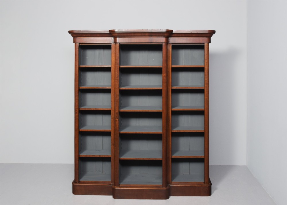 A large mid-Victorian three-section open mahogany bookcase with a breakfront centre, filled with rows of leather-bound books. View IX