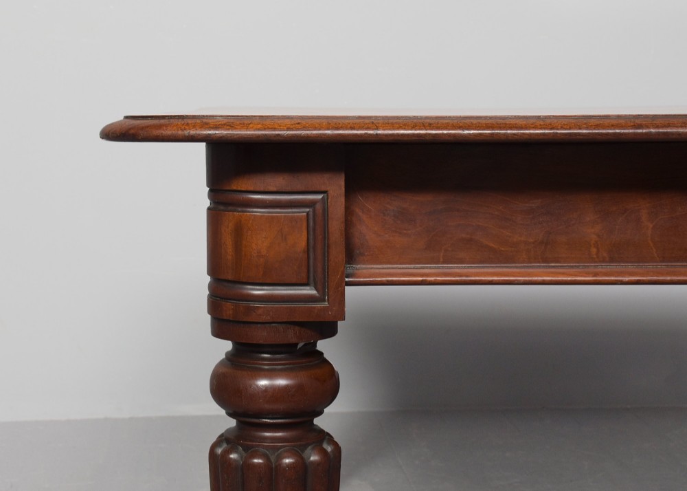 A rectangular George IV mahogany extending dining table with rounded corners, reeded turned legs, and brass castors. View IX