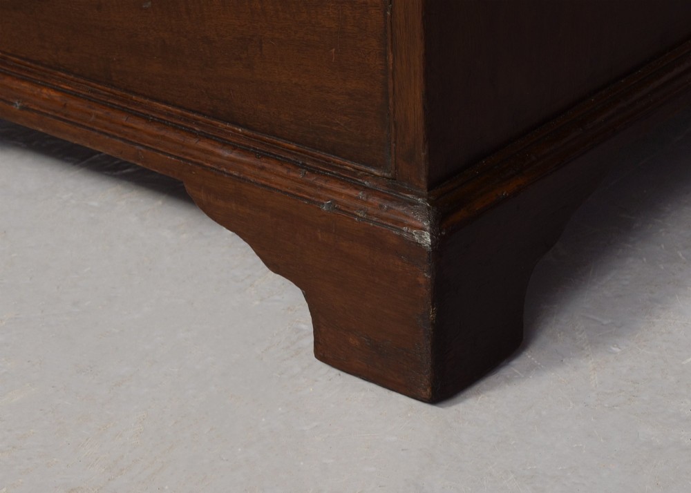 A large George III mahogany partners desk featuring a green leather writing surface, dual pedestals with brass swan-neck handles, and bracket feet. View VII