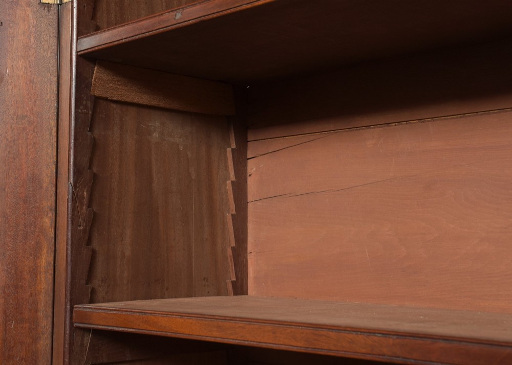 A late eighteenth-century George III mahogany secretaire bookcase featuring an upper glazed cabinet and a lower chest of drawers on bracket feet. View X