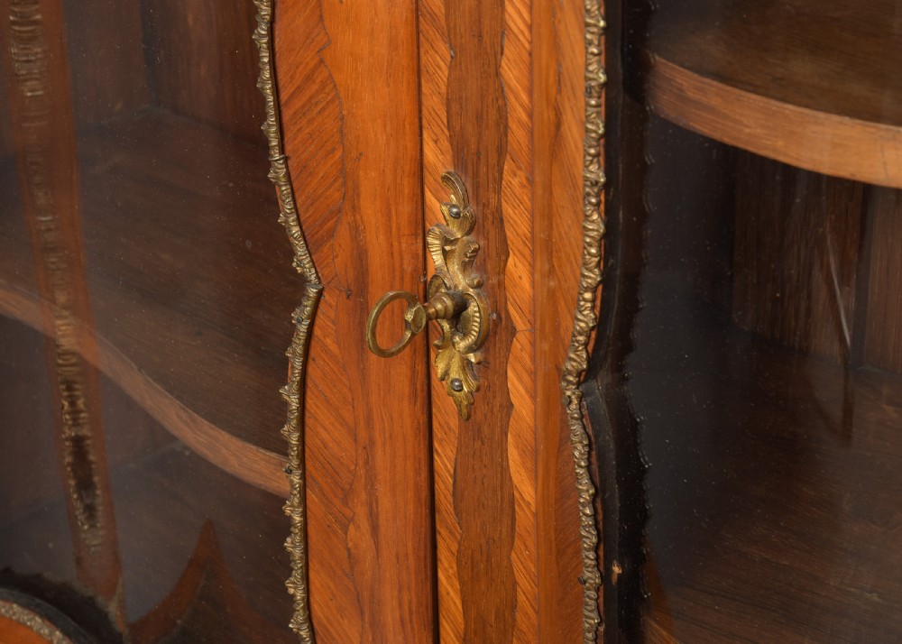 A nineteenth-century French style kingwood and walnut writing desk featuring an upper glazed display cabinet, brass top gallery, cabriole legs, and gilded metal mounts. View III