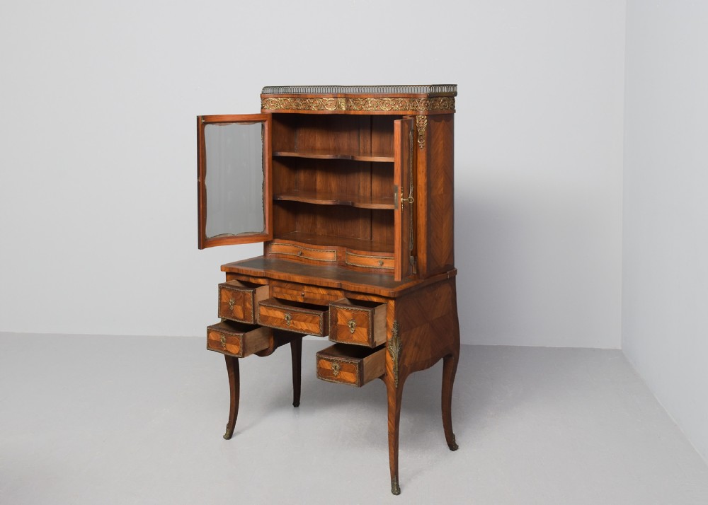A nineteenth-century French style kingwood and walnut writing desk featuring an upper glazed display cabinet, brass top gallery, cabriole legs, and gilded metal mounts. View V