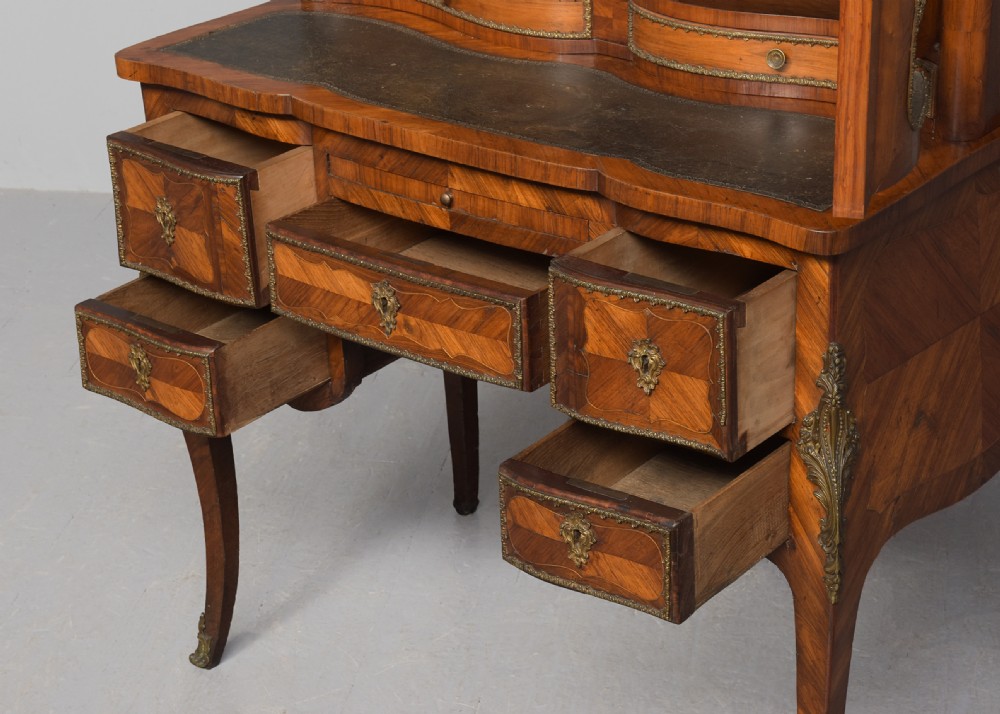 A nineteenth-century French style kingwood and walnut writing desk featuring an upper glazed display cabinet, brass top gallery, cabriole legs, and gilded metal mounts. View VII