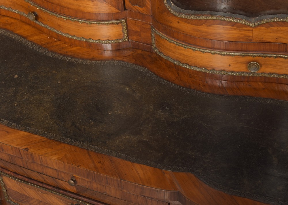 A nineteenth-century French style kingwood and walnut writing desk featuring an upper glazed display cabinet, brass top gallery, cabriole legs, and gilded metal mounts. View VIII