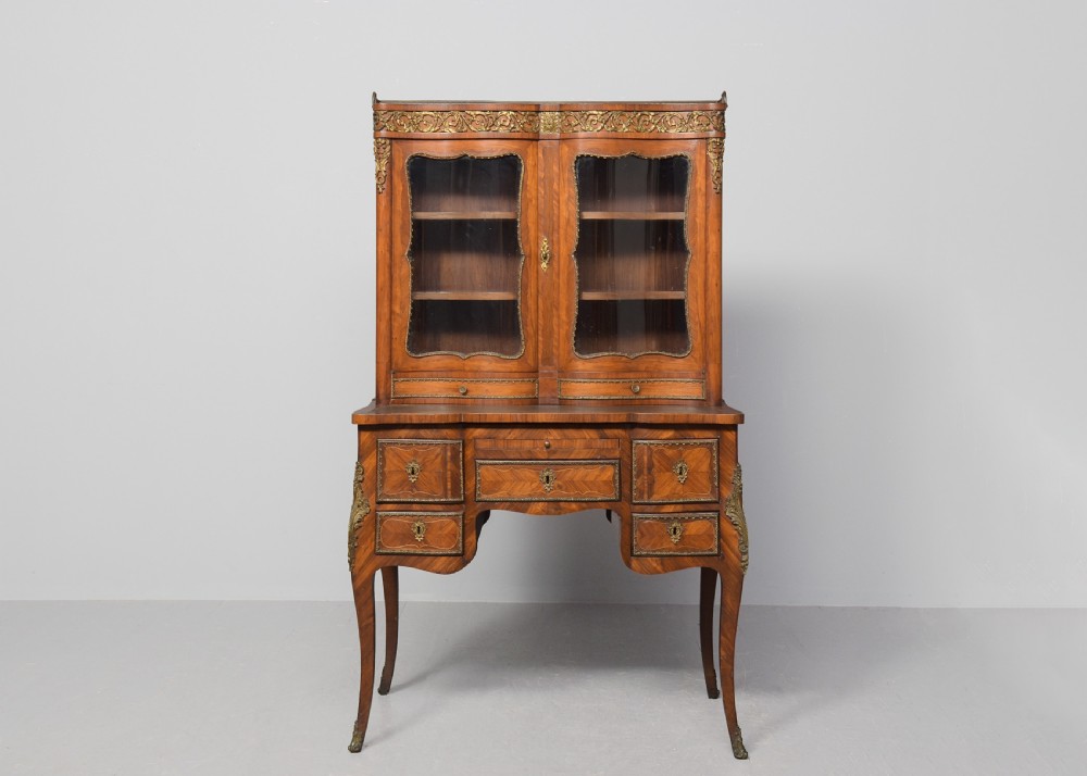A nineteenth-century French style kingwood and walnut writing desk featuring an upper glazed display cabinet, brass top gallery, cabriole legs, and gilded metal mounts. View XII