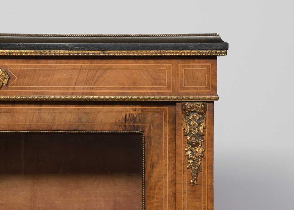 A pair of Victorian burr walnut pier cabinets with single glazed doors, ebonised trim, ormolu corner mounts, and oval porcelain plaques. View II