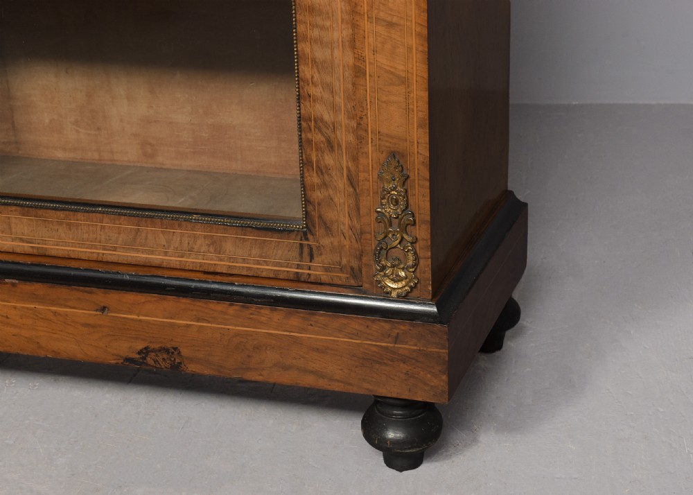 A pair of Victorian burr walnut pier cabinets with single glazed doors, ebonised trim, ormolu corner mounts, and oval porcelain plaques. View III