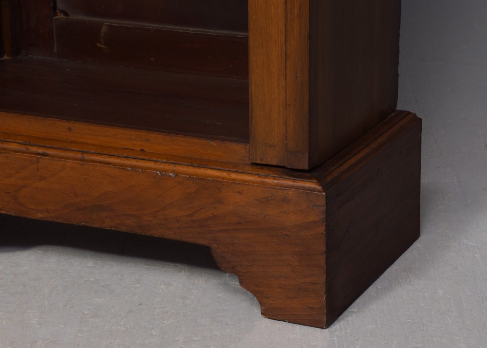 A tall mid-Victorian mahogany three-section open bookcase featuring a moulded top cornice and a solid plinth base filled with books. View IV