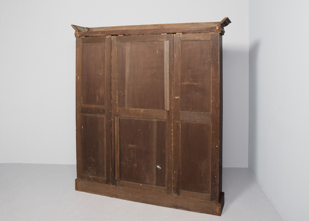 A tall mid-Victorian mahogany three-section open bookcase featuring a moulded top cornice and a solid plinth base filled with books. View IX