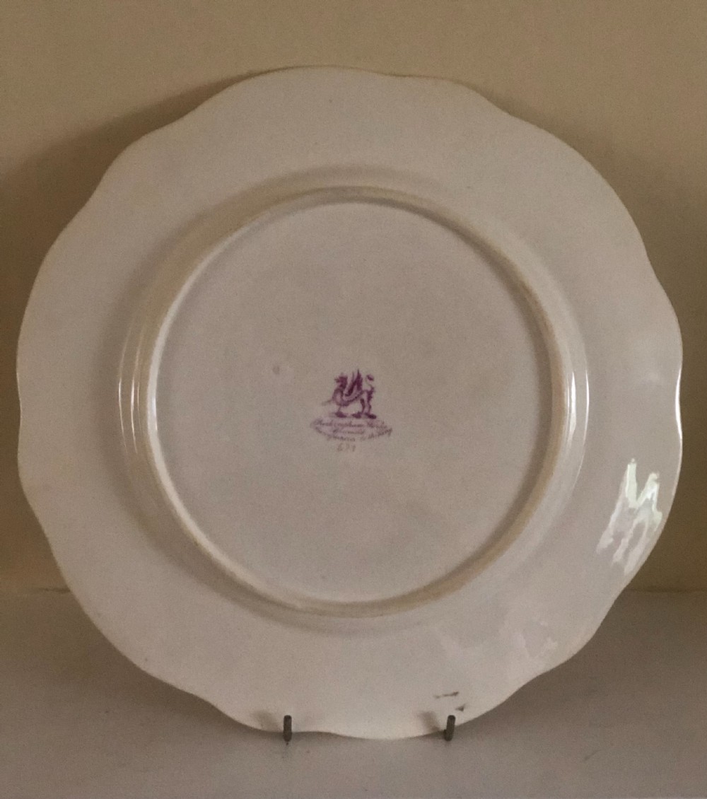 An antique circular white porcelain dessert plate featuring a scalloped edge with green scroll moulding, gilded details, and hand-painted floral sprays across the centre. View II
