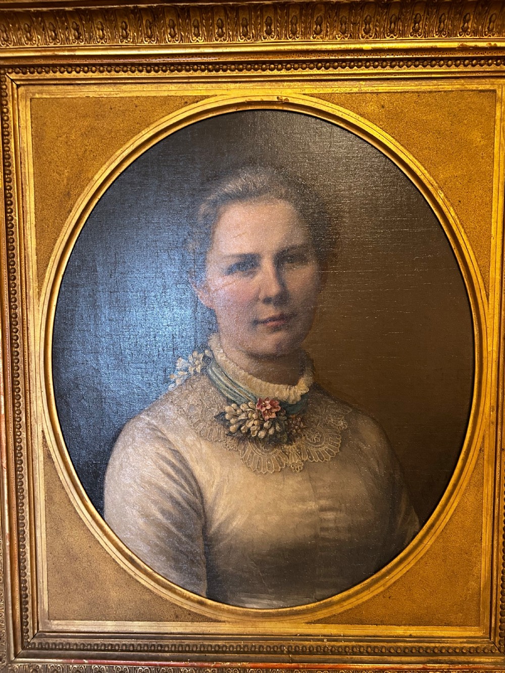 A late nineteenth-century oil portrait depicting a woman in a light dress within an oval mount and ornate rectangular gilt frame. View II