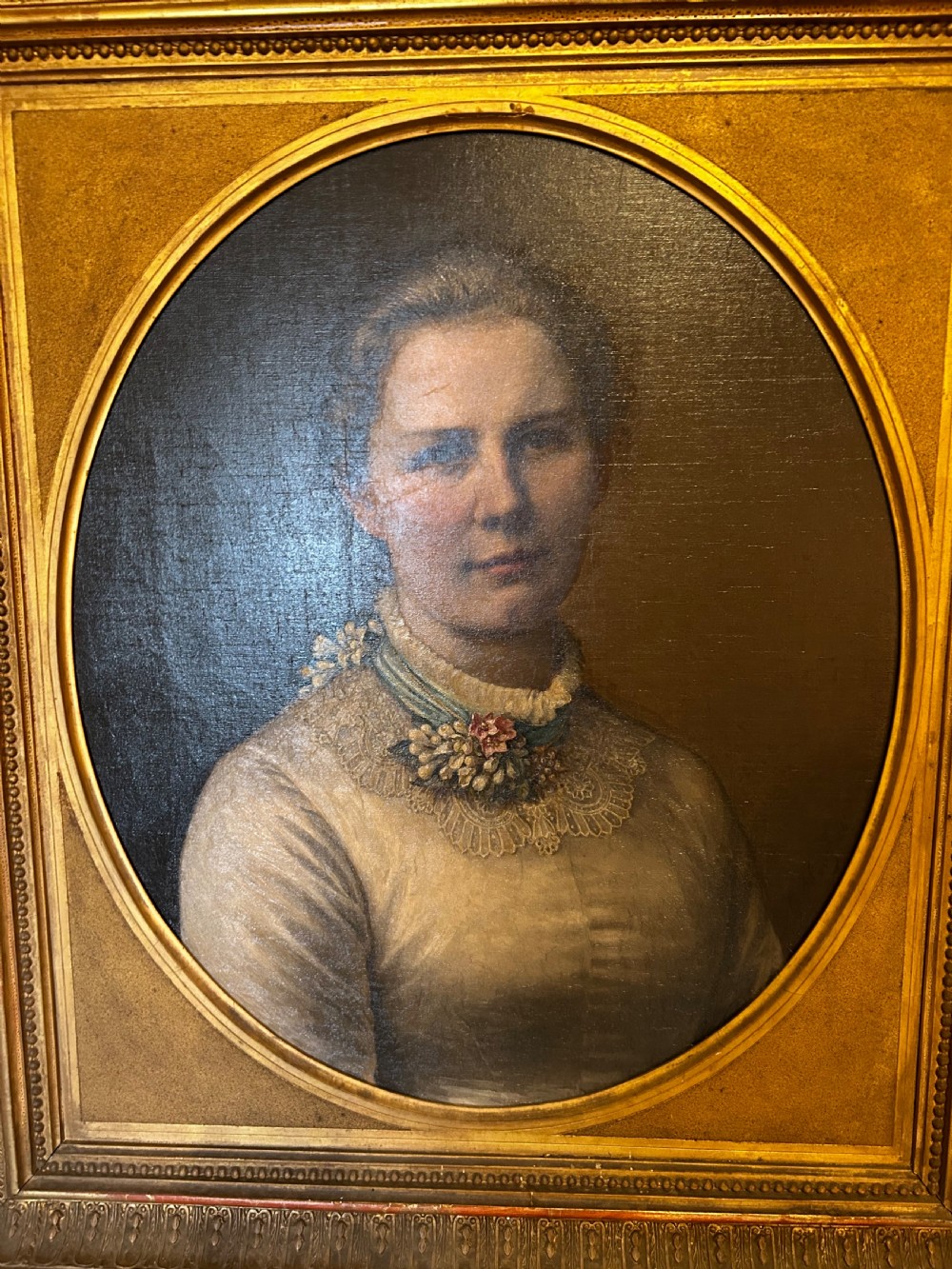 A late nineteenth-century oil portrait depicting a woman in a light dress within an oval mount and ornate rectangular gilt frame. View IV
