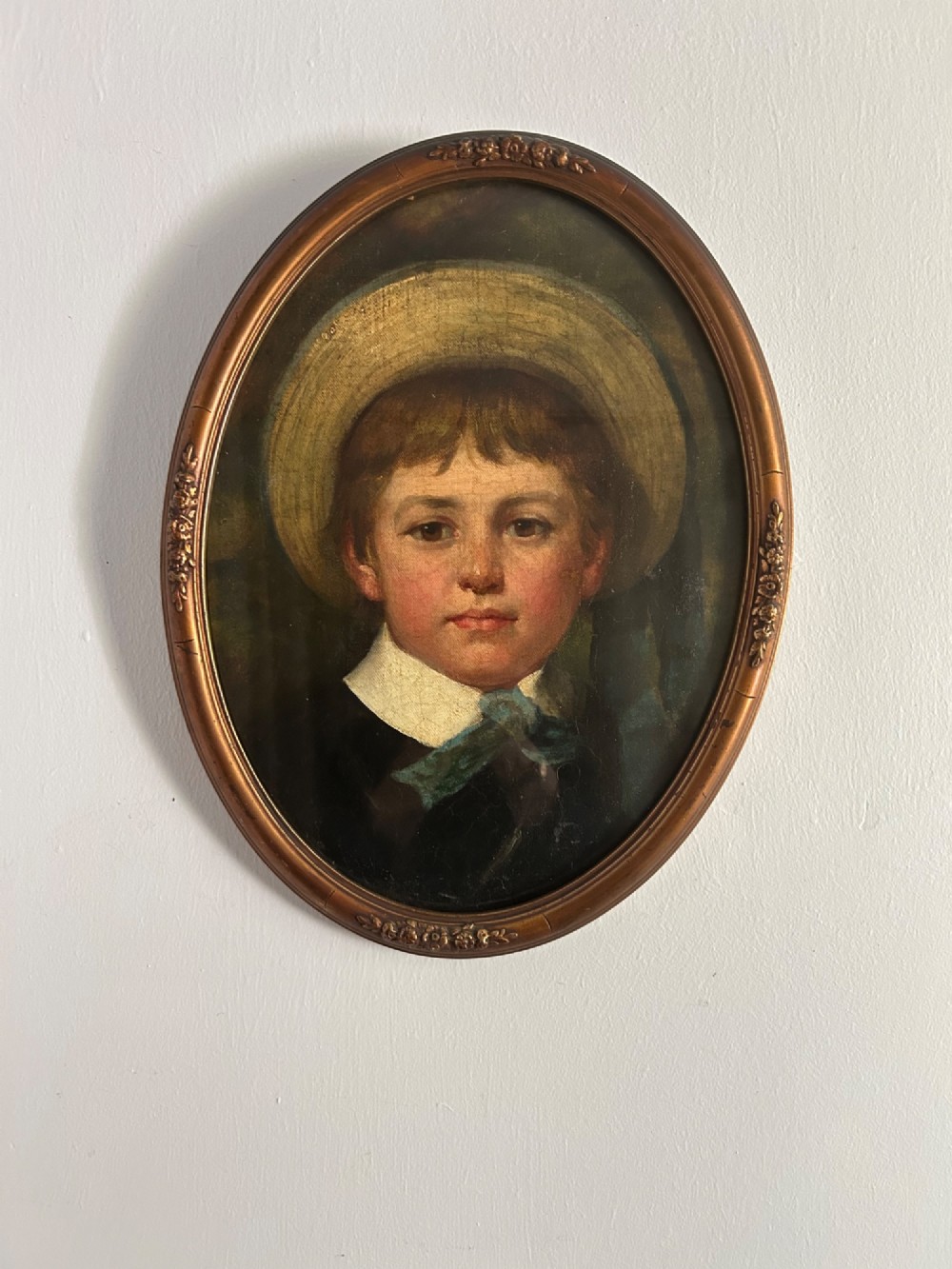A delightful Victorian oil painting of a young boy wearing a straw boater