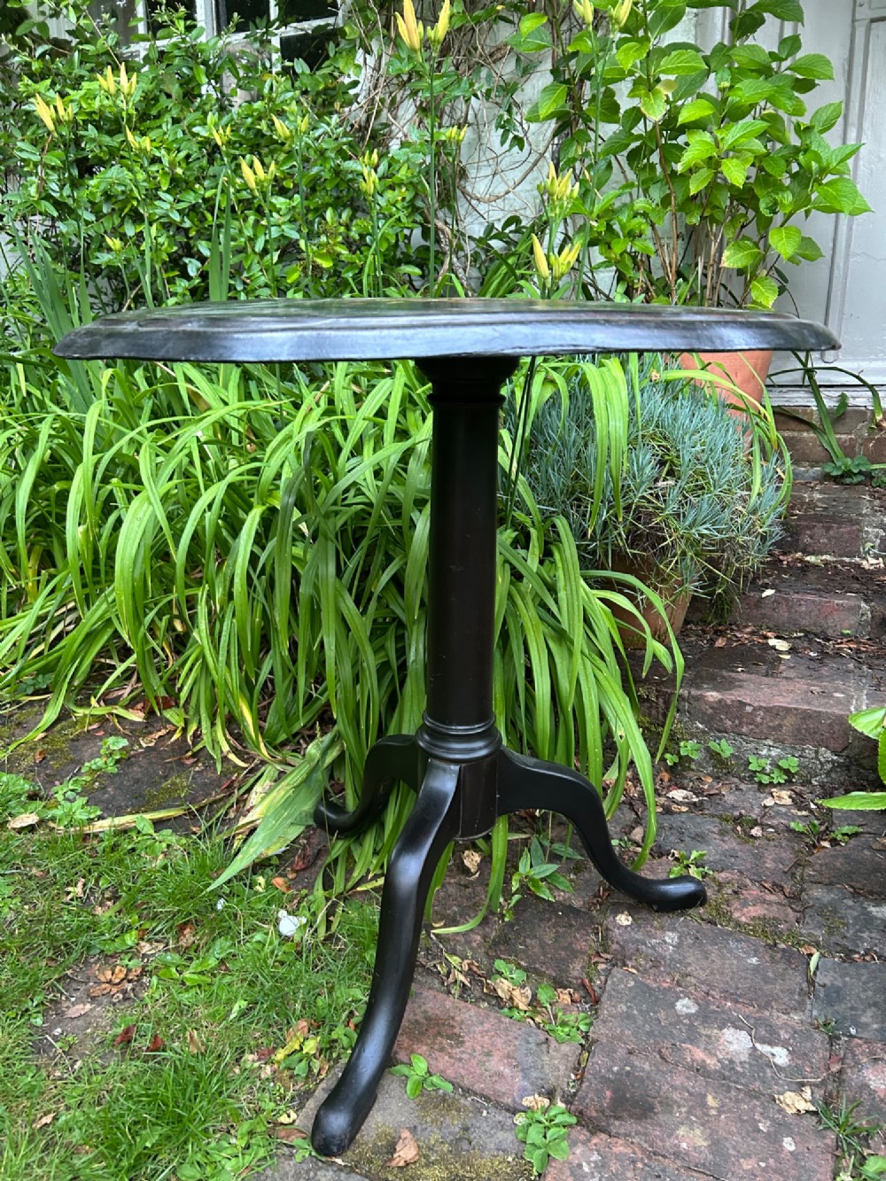 A Victorian black papier mache wine table featuring hand-painted botanical motifs, mother-of-pearl inlay, a scalloped edge, and a tripod base. View II