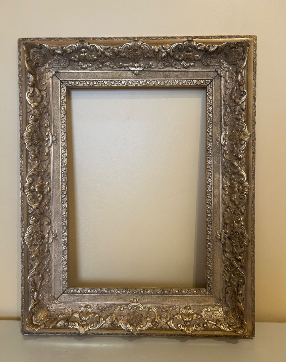 A rectangular 19th-century Rococo Revival style frame with intricate gilded floral, shell, and scrollwork gesso mouldings.