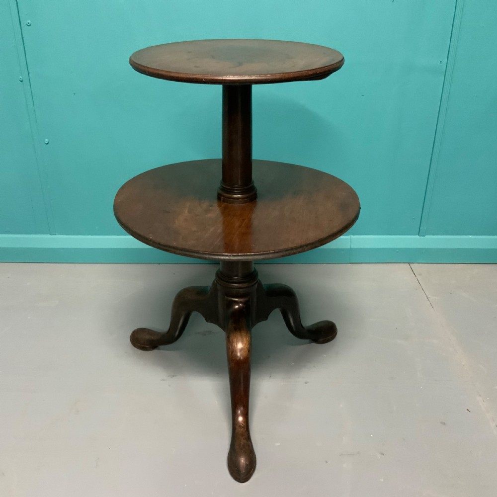 A George II mahogany two-tier dumb waiter with graduated circular surfaces, a turned central column, and a tripod base. View II