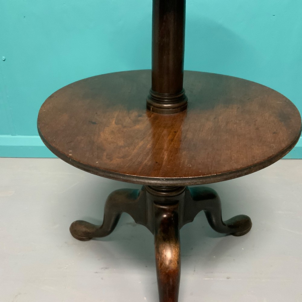 A George II mahogany two-tier dumb waiter with graduated circular surfaces, a turned central column, and a tripod base. View III