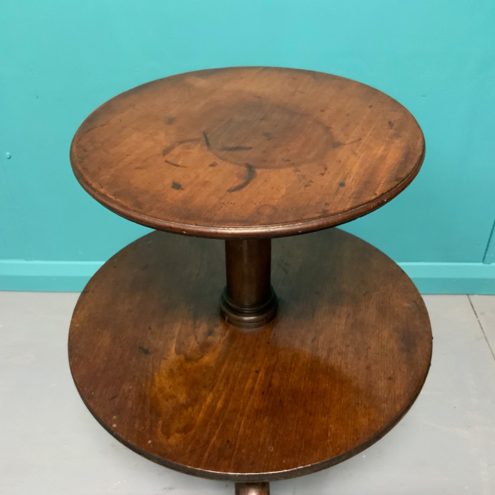 A George II mahogany two-tier dumb waiter with graduated circular surfaces, a turned central column, and a tripod base. View V