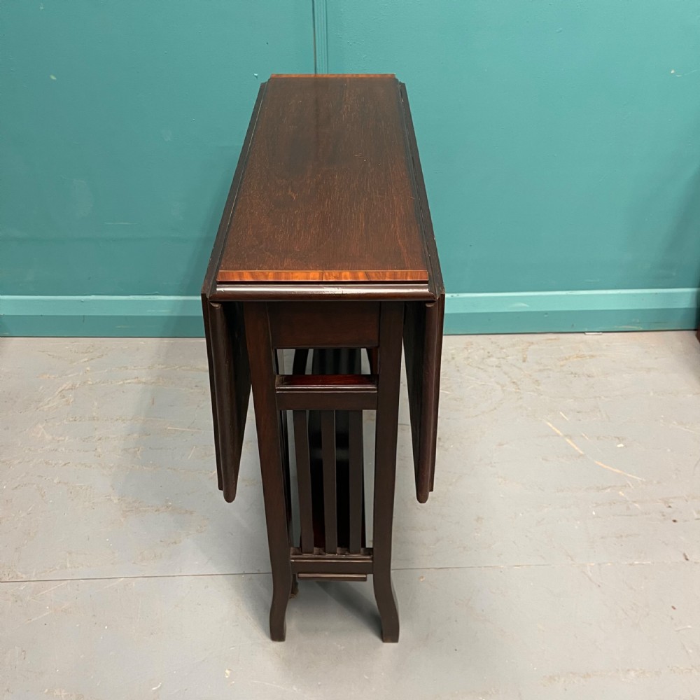 An Edwardian dark mahogany drop-leaf Sutherland table featuring satinwood crossbanding around the tabletop edge and slender gate-leg supports. View III