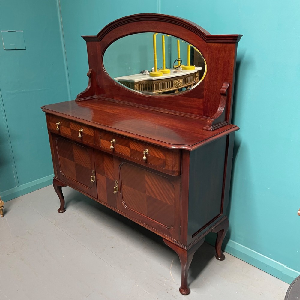 An Edwardian mahogany mirror-back sideboard featuring chevron parquetry cupboard doors, two top drawers, brass pulls, and cabriole legs. View II