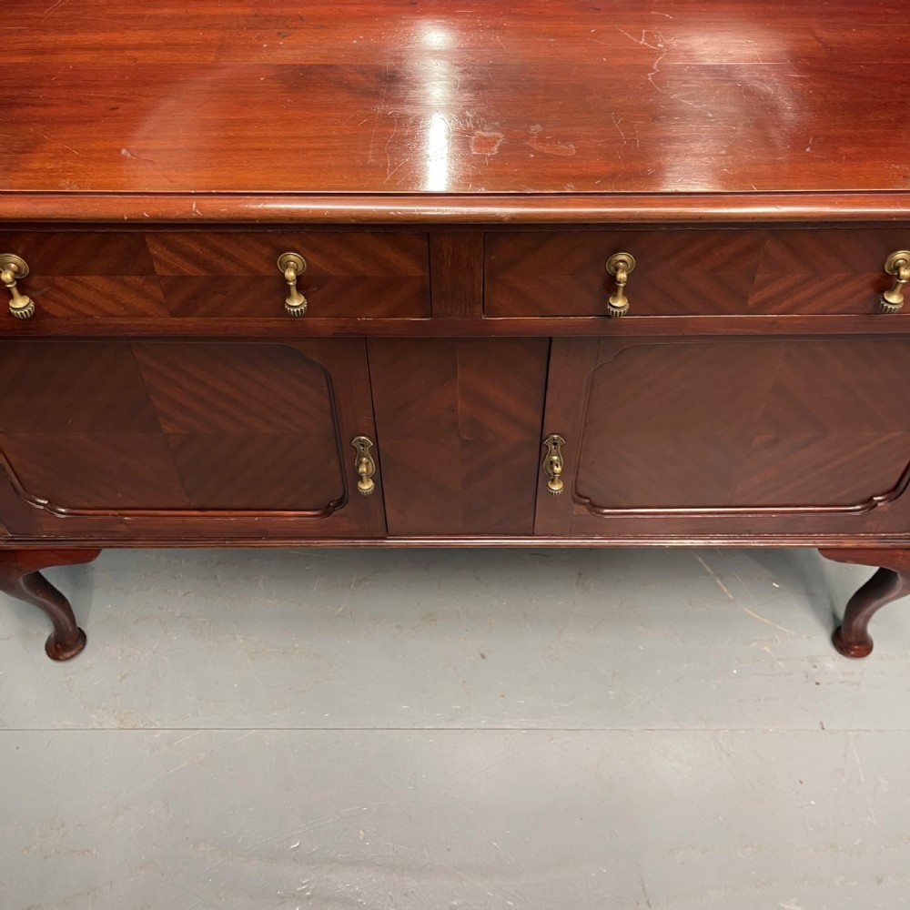 An Edwardian mahogany mirror-back sideboard featuring chevron parquetry cupboard doors, two top drawers, brass pulls, and cabriole legs. View III