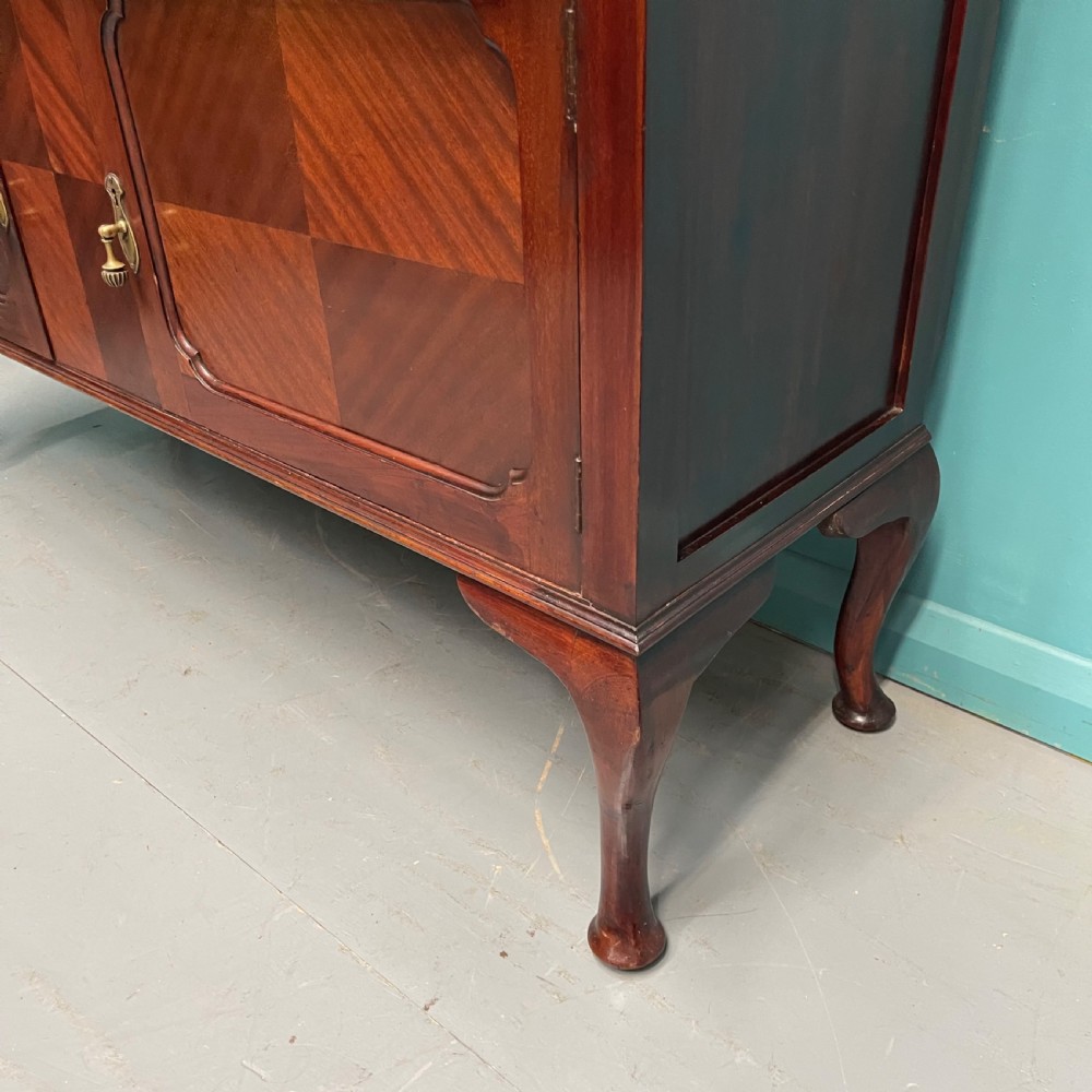 An Edwardian mahogany mirror-back sideboard featuring chevron parquetry cupboard doors, two top drawers, brass pulls, and cabriole legs. View V