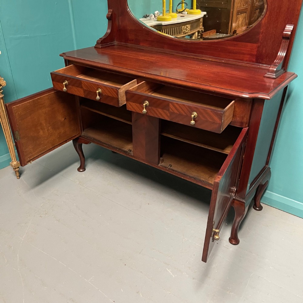 An Edwardian mahogany mirror-back sideboard featuring chevron parquetry cupboard doors, two top drawers, brass pulls, and cabriole legs. View VII