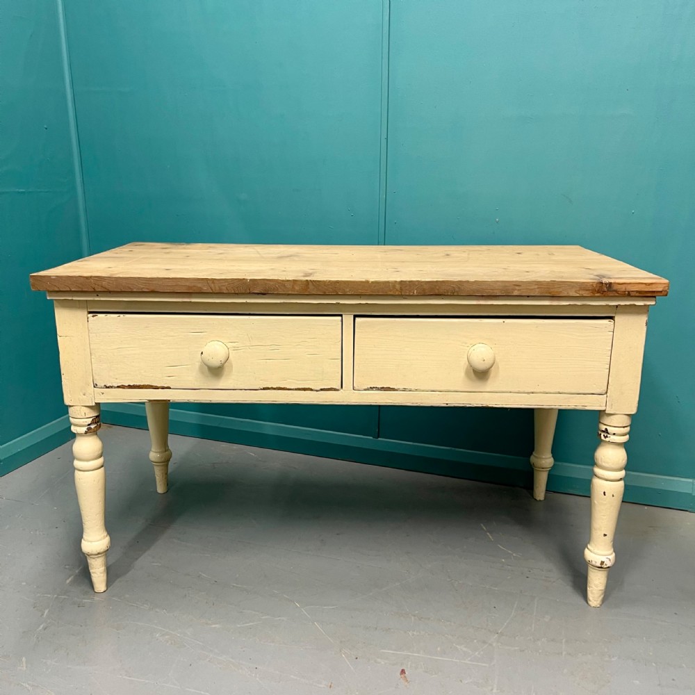 An antique pine server featuring a scrubbed rectangular wooden top, a cream-painted base, two drawers with round wooden knobs, and four turned legs.
