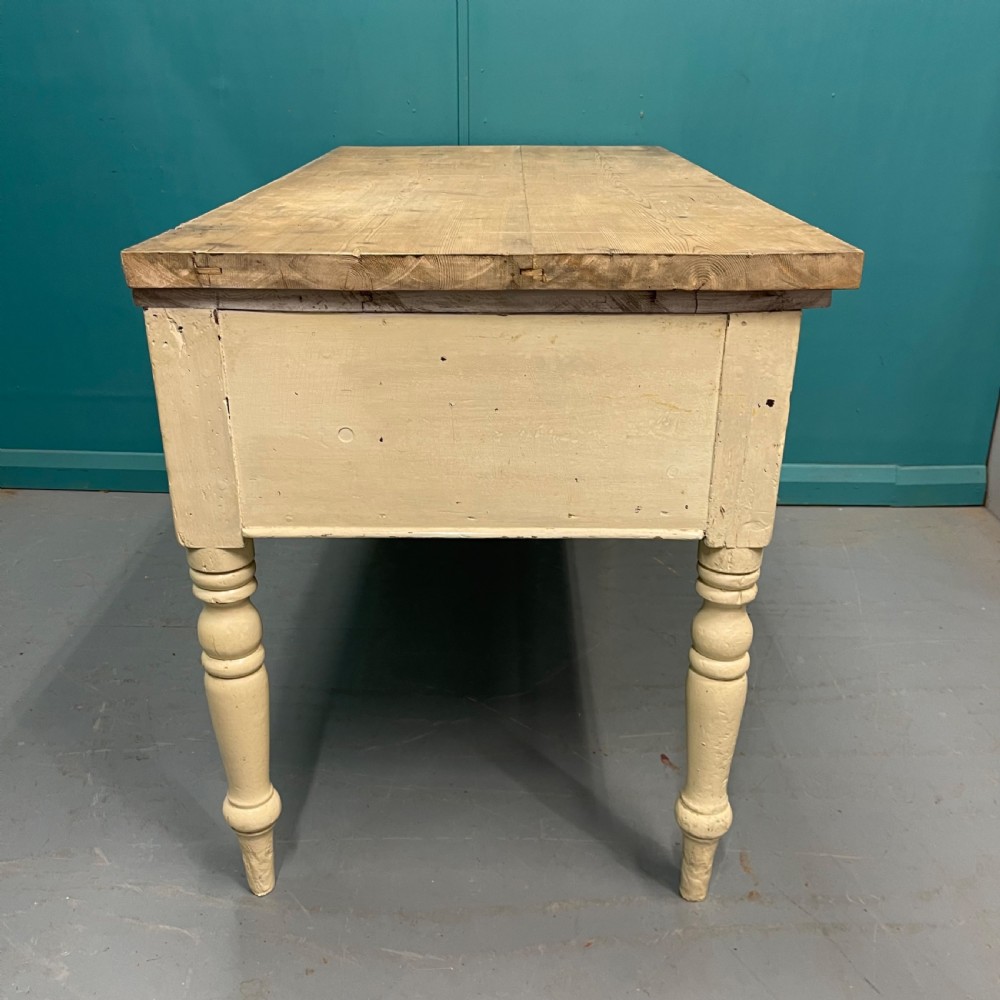 An antique pine server featuring a scrubbed rectangular wooden top, a cream-painted base, two drawers with round wooden knobs, and four turned legs. View VII