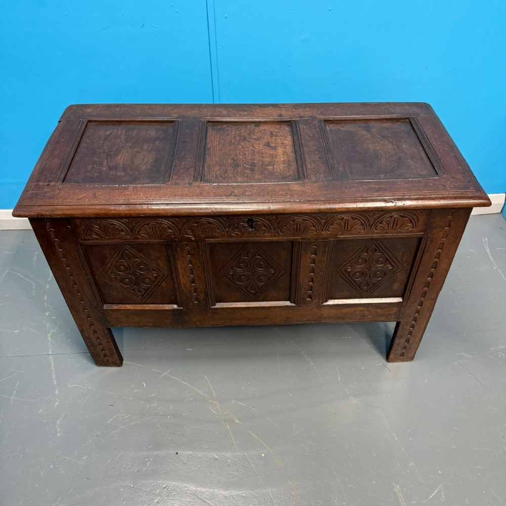 An 18th-century dark oak coffer featuring three carved diamond lozenge panels, an arcaded top rail, and a panelled hinged lid. View III
