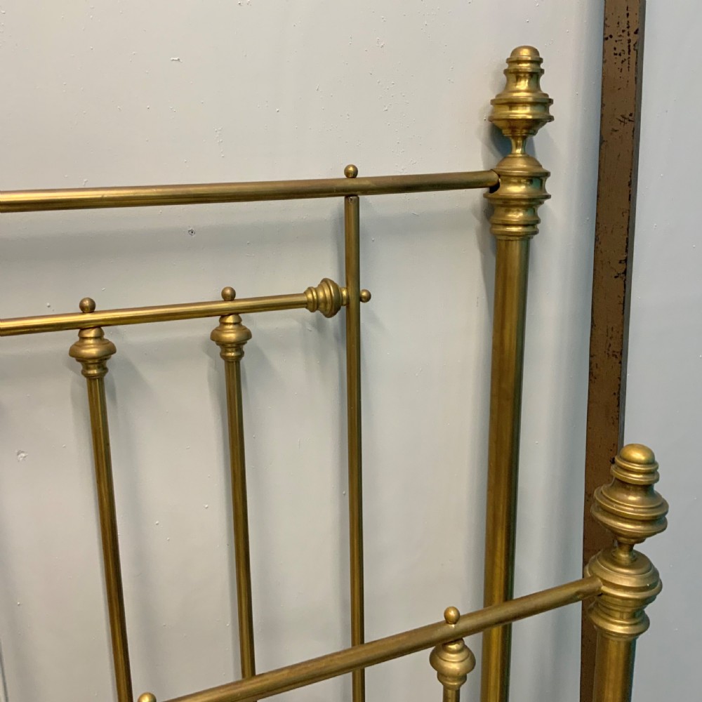 Victorian 5ft king-size brass bed frame featuring vertical spindles, turned finials, and a central cast decorative motif alongside original side rails. View III