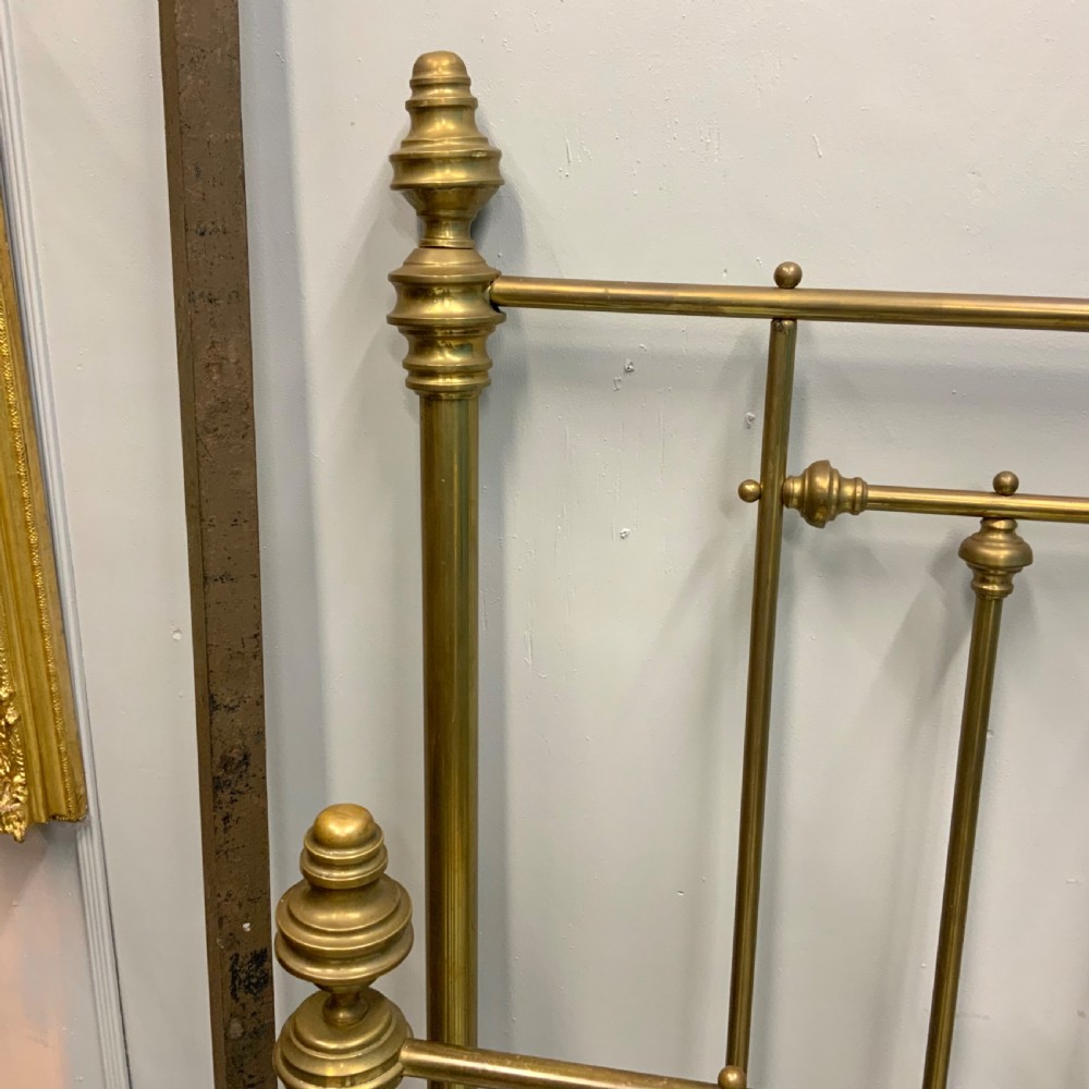 Victorian 5ft king-size brass bed frame featuring vertical spindles, turned finials, and a central cast decorative motif alongside original side rails. View IV