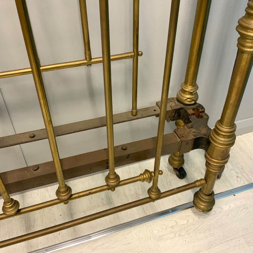 Victorian 5ft king-size brass bed frame featuring vertical spindles, turned finials, and a central cast decorative motif alongside original side rails. View V