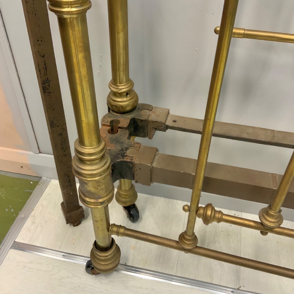 Victorian 5ft king-size brass bed frame featuring vertical spindles, turned finials, and a central cast decorative motif alongside original side rails. View VI