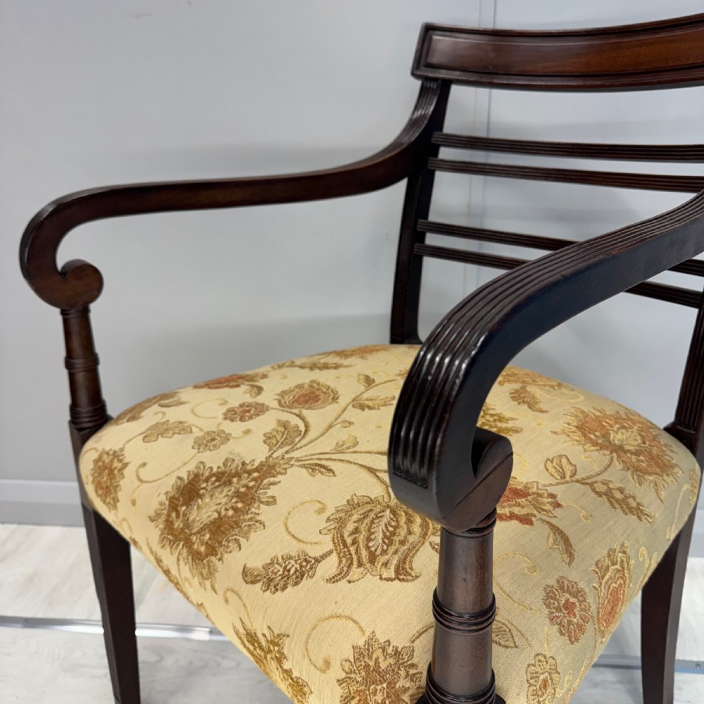 A dark mahogany Regency carver armchair featuring reeded scrolled arms, horizontal slat backrest, fluted front legs, and a golden floral patterned upholstered seat. View II
