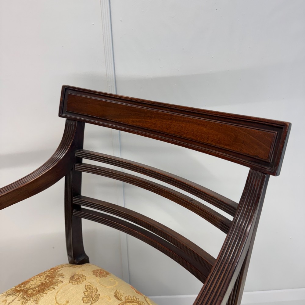 A dark mahogany Regency carver armchair featuring reeded scrolled arms, horizontal slat backrest, fluted front legs, and a golden floral patterned upholstered seat. View III