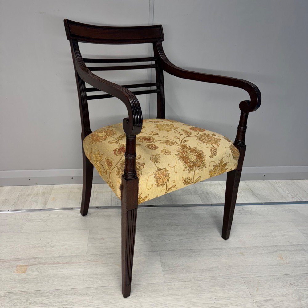 A dark mahogany Regency carver armchair featuring reeded scrolled arms, horizontal slat backrest, fluted front legs, and a golden floral patterned upholstered seat. View V